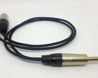 May include: A black braided cable with two 1/4 inch male connectors on one end and a single 1/4 inch female connector on the other end.