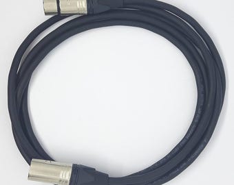 May include: A black XLR cable with two silver connectors. The cable is coiled and the connectors are visible.