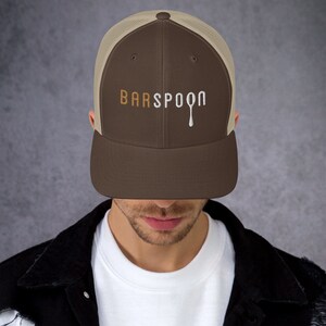 May include: A brown and beige trucker hat with a white embroidered logo that says "BARSPOON" with a dripping spoon graphic.
