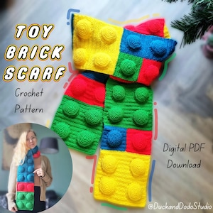 May include: A crochet scarf pattern inspired by toy bricks. The scarf is made of colourful yarn in red, yellow, green, and blue. The pattern is available as a digital PDF download. The text "Toy Brick Scarf Crochet Pattern" and "Digital PDF Download" is visible in the image.