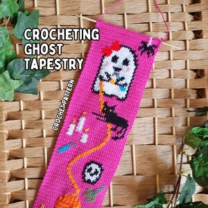 K&ouml;nnte beinhalten: Ein pinkfarbenes geh&auml;keltes Wandbehang mit Halloween-Motiv. Der Wandbehang zeigt einen wei&szlig;en Geist mit roter Schleife, eine schwarze Katze, Kerzen, einen Totenkopf und einen K&uuml;rbis. Der Text "CROCHETING GHOST TAPESTRY" und "CROCHET PATTERN" sind ebenfalls sichtbar.