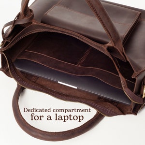 May include: Brown leather tote bag with a zippered closure and a dedicated compartment for a laptop. The bag has a top handle and a zippered pocket on the front.