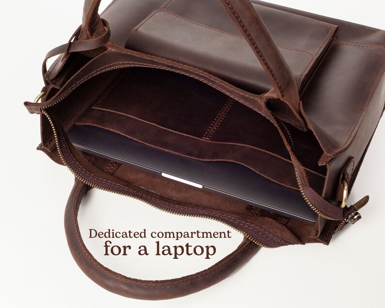May include: Brown leather tote bag with a zippered closure and a dedicated compartment for a laptop. The bag has a top handle and a zippered pocket on the front.
