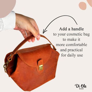 May include: A brown leather cosmetic bag with a handle, a gold-colored clasp, and the text "Add a handle to your cosmetic bag to make it more comfortable and practical for daily use." The bag is held by a hand.