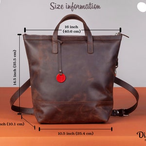 May include: Brown leather backpack with a top handle and adjustable straps. The backpack measures 14.5 inches tall, 10.5 inches wide, and 16 inches in height. The bag has a red circle logo on the front.