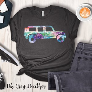 May include: Dark grey heather t-shirt with a colorful silhouette of a jeep. The jeep is outlined with a tropical leaf pattern.