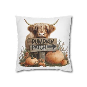 May include: White square pillow featuring a Highland cow with long, shaggy brown fur and curved horns. A wooden sign reads "PUMPKIN PATCH" with an arrow. Pumpkins and fall foliage surround the sign, creating a seasonal theme.
