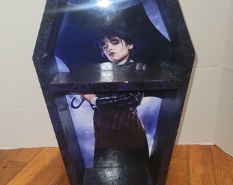 Estante expositor de ataúdes con temática de Miércoles Addams