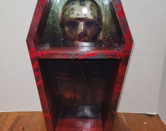 Estantería expositora de ataúdes con temática de Jason Voorhees ensangrentado