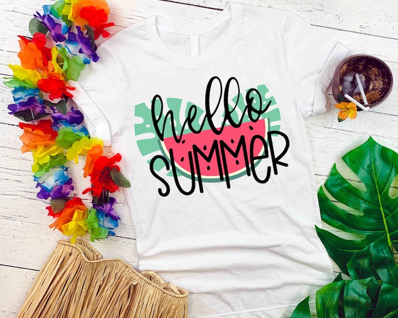 Puede incluir: Camiseta blanca con un gr&aacute;fico de sand&iacute;a verde y rosa y el texto "hello summer" en negro.