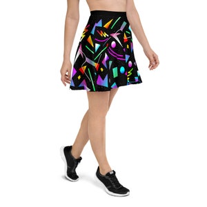 May include: A black skater skirt with a colorful geometric pattern. The skirt features a variety of shapes and colors, including pink, blue, green, yellow, and orange. The skirt is made of a soft, comfortable fabric and is perfect for a casual or dressy occasion.