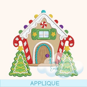 Pode incluir: Um design de aplicação de casa de gengibre com telhado branco, detalhes de bengalas doces e árvores de Natal. A casa tem uma porta de madeira, uma janela verde com estrelas amarelas e luzes coloridas. A palavra "APPLIQUE" está na parte inferior.