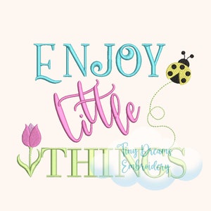 Może przedstawiać: Haftowany wzór z tekstem "Enjoy little things" w kolorze różowym, niebieskim i zielonym. Wzór zawiera również różową tulipan i żółtą biedronkę.