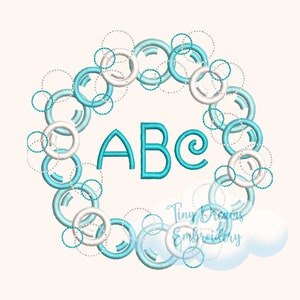 Puede incluir: Un diseño de círculos azules y blancos con las letras ABC en el centro. El diseño está rodeado de una nube con el texto "Tiny Dreams Embroidery".