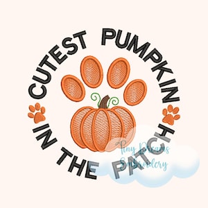 Puede incluir: Un diseño de bordado negro y naranja con una huella de pata y una calabaza. El texto alrededor del diseño dice "Cutest Pumpkin in the Patch".