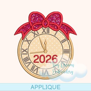 Könnte beinhalten: Ein Uhrendesign mit einer roten Glitzer-Schleife oben. Das Zifferblatt ist beige mit römischen Ziffern und dem Jahr 2026 in Rot. Das Wort "APPLIQUE" steht unten.