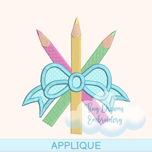 Peut inclure: Motif d'applique avec trois crayons de couleur rose, jaune et vert, disposés avec un nœud bleu clair à pois blancs. Le mot "APPLIQUE" est affiché en bas, avec le texte "Tiny Dreams Embroidery" dans le coin.