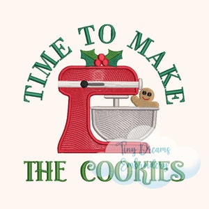 Könnte beinhalten: Ein roter Küchenmixer mit einem Lebkuchenmann in der Schüssel. Der Mixer hat einen Stechpalmenzweig mit roten Beeren oben drauf. Der Text um den Mixer herum lautet "Time to Make the Cookies".
