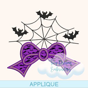 May include: Purple and black Halloween applique with a bow and a spiderweb with bats. The text "Tiny Dreams Embroidery" is in the lower right corner.