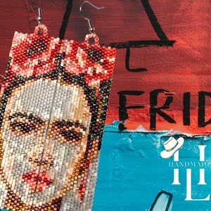 May include: A pair of beaded earrings featuring a colorful portrait of Frida Kahlo. The earrings are rectangular in shape and are made with small, colorful beads. The background is a red, blue, and white painted wall with the word "FRIDAY" written in black.