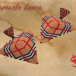 Peut inclure: Une paire de boucles d'oreilles de forme triangulaire avec un motif écossais brun, noir, blanc et rouge. Les boucles d'oreilles sont faites de perles et ont un petit pendentif triangulaire en haut.