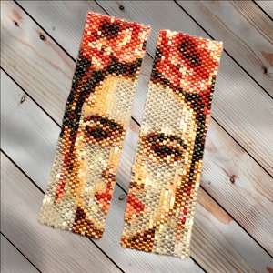 May include: A pair of beaded earrings featuring a portrait of Frida Kahlo. The earrings are made with small, colorful beads and have a rectangular shape. The portrait is detailed and includes Frida's signature unibrow and flower crown.