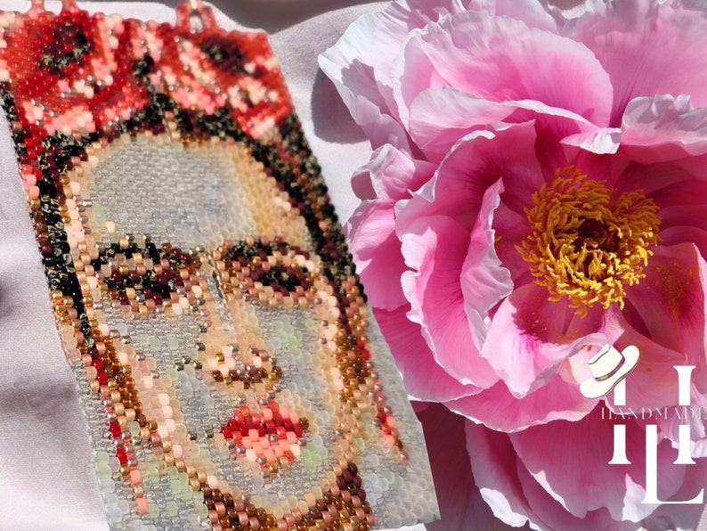 May include: A beaded portrait of Frida Kahlo with a pink peony flower in the background. The portrait is made with colorful beads and the flower is in full bloom.