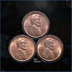 May include: Three copper-colored 1953 Lincoln pennies arranged in a triangular pattern. Each coin features the profile of Abraham Lincoln, the words "Liberty," and "In God We Trust." The text "BU Cents" is visible at the bottom.