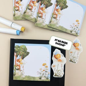 May include: Stationery set with a bee and flower design. The image shows several notepads, a free maxi sticker, and two white markers with yellow and blue tips. The text "free maxi sticker" is visible. The notepads have a blue and green border.