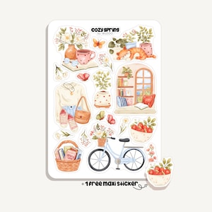 May include: A sticker sheet with watercolour illustrations of cosy spring scenes. It includes a bicycle with a flower basket, a sleeping cat, a cup of tea, and other decorative elements. The text "COZY SPRING" is at the top.