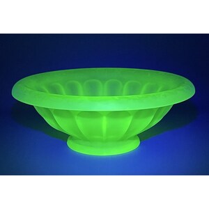 May include: A bright green glass bowl with a fluted design. The bowl is made of uranium glass and glows under a black light.