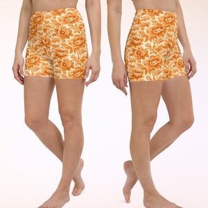 May include: A pair of athletic shorts with a floral print in shades of orange and white. The shorts are made of a stretchy, comfortable fabric and have a high waist.
