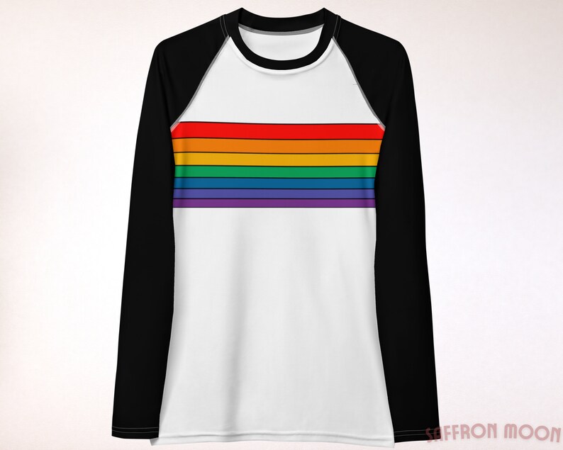 May include: A white long-sleeve shirt with black raglan sleeves and a rainbow stripe design across the chest.
