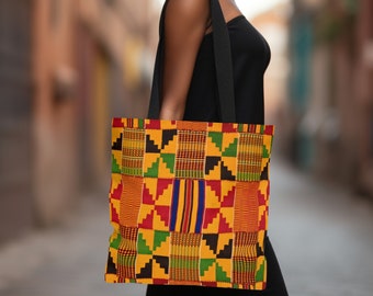 May include: A large tote bag with a colourful African print design. The bag is made of fabric and has black straps. The print features geometric shapes in yellow, red, green, and black.