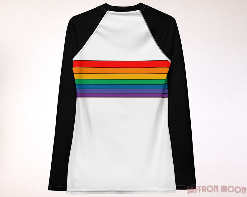 May include: A white long-sleeve shirt with black raglan sleeves and a rainbow stripe design across the chest.