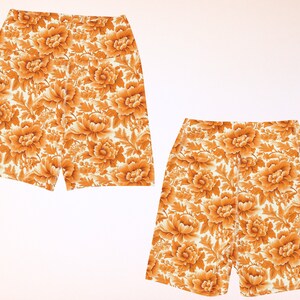 May include: Two pairs of white shorts with a floral pattern in shades of orange and yellow.
