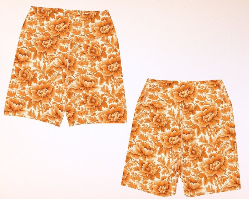 May include: Two pairs of white shorts with a floral pattern in shades of orange and yellow.