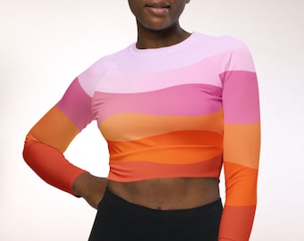 May include: A long-sleeved, cropped top with a colorful, wavy pattern in shades of pink, orange, and red.