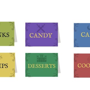 May include: Six colorful table signs with text for food and drinks. The signs are green, purple, blue, yellow, green, and red. The text includes "DRINKS", "CANDY", "CAKE", "CHIPS", "DESSERTS", and "COOKIES". Each sign has decorative flourishes.