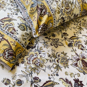 May include: Cream-colored bedding set with a floral pattern in shades of yellow, brown, and green. The set includes two pillowcases and a sheet, all featuring a detailed botanical design. The text "https://ploutus.biz" is visible at the bottom.