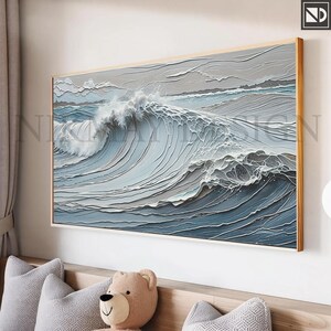 May include: A framed painting of a large ocean wave crashing in the sea. The wave is depicted in shades of blue and white, with a textured, almost 3D effect. The background is a light gray, suggesting a cloudy sky.