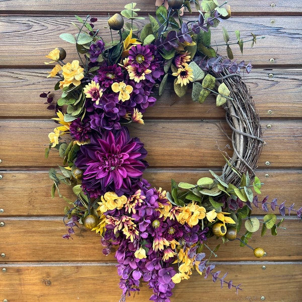 Lush wreath for front door in purple and yellow tones, with sunflowers and assorted autumn foliage. Unique wreath for year round decor.