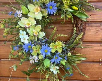 Couronne de printemps la plus vendue pour porte d'entrée dans des tons vert et lavande. Décor de porte de marguerites bleues et vertes, orchidées, tulipes. 2 tailles