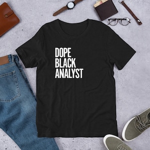Könnte beinhalten: Schwarzes T-Shirt mit dem Text "Dope Black Analyst" in weißen Buchstaben.