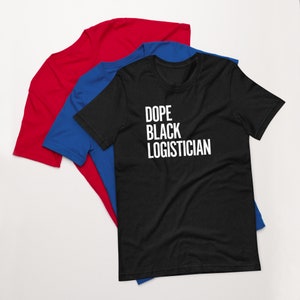 May include: A black t-shirt with the text "Dope Black Logistician" printed in white on the front. The t-shirt is folded and displayed on top of a blue t-shirt and a red t-shirt.