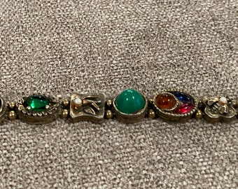 Old brass or bronze tone metal segment bracelet with charms with faux stones, pearl charm bracelet