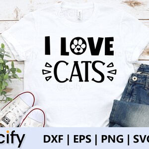 May include: White t-shirt with black text that reads "I LOVE CATS" with a paw print graphic in the middle of the word "LOVE".
