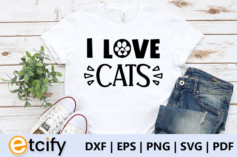 May include: White t-shirt with black text that reads "I LOVE CATS" with a paw print graphic in the middle of the word "LOVE".