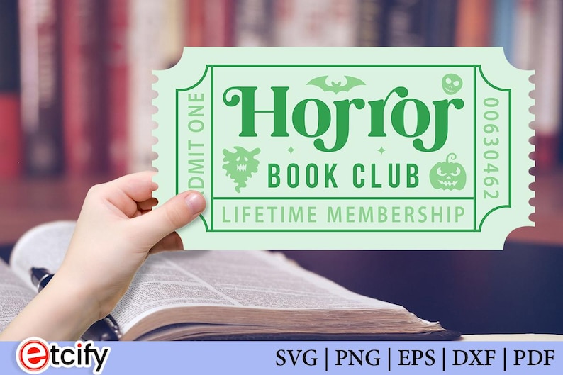 May include: A pale green ticket with the words "Horror Book Club Lifetime Membership" in green. The ticket features a bat, skull, and pumpkin graphic. The ticket is held over an open book.