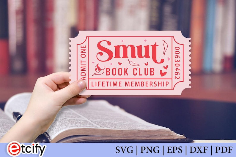 May include: A pink ticket with the words "Smut Book Club Lifetime Membership" in red. The ticket is held over an open book. The ticket has a serrated edge and the number 00630462.